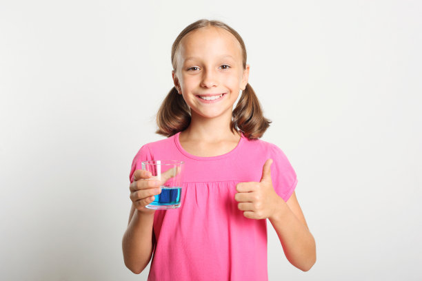 那孩子正在用漱口水漱口。儿童口腔健康图片下载