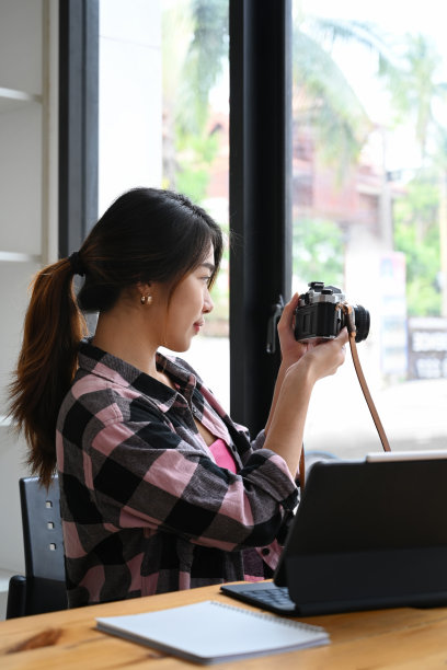 年轻的女摄影师用老式胶卷相机拍照。图片下载