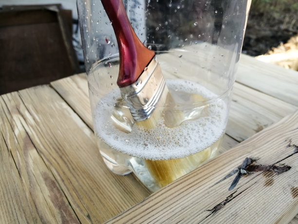 油漆刷在一个罐子里与木材防腐剂。图片下载