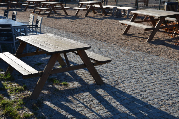 木制的座位区，长椅沿水边排列着天然木材。池塘边的露台，有一张野餐长凳和几张老式的圆桌，就像在咖啡馆里一样。在冰雪覆盖的冬天，遮阳伞会折叠起来图片下载