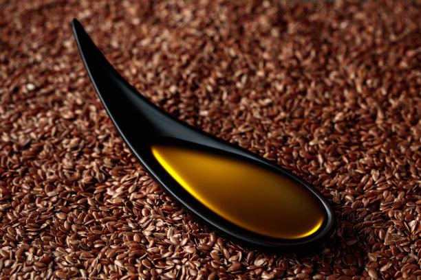 用黑色小碗盛亚麻籽油。图片下载