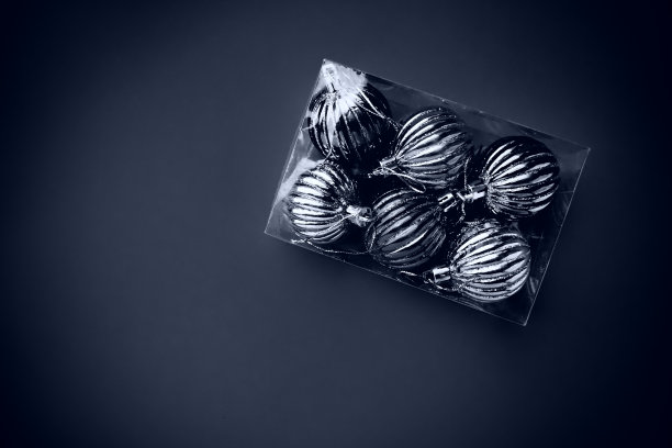 有圣诞树装饰的盒子。或购买的礼物。新年快乐，圣诞快乐。一堆闪亮的球。黑白单色照片与晕图片下载