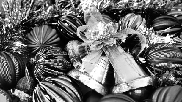 圣诞背景有圣诞装饰物、节日球、铃铛、蝴蝶结、圣诞树雨。黑白黑白复古装饰水平照片。新年快乐，圣诞快乐。图片下载