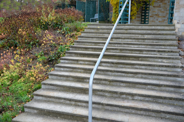 带有中央导向栏杆的楼梯。用一根弯曲的镀锌管当把手图片下载