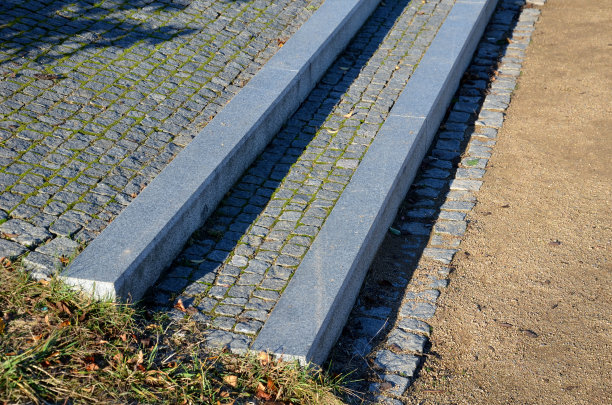 通往公园的石阶同时也是长椅。灰色水泥干净、光滑、光亮。铺花岗石方块打谷碎石路。长满植物。防打滑,两个图片下载