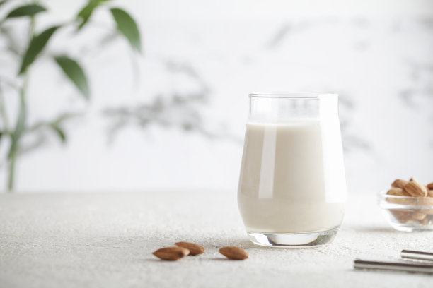 纯素食杏仁牛奶，白色背景上有坚果。副本的空间。健康的素食。有选择性的重点。非乳品替代奶图片下载