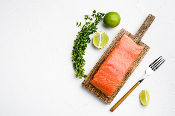 生三文鱼鱼片鱼肉，与香草，在白色石头桌子的背景，顶视图平放，与复制空间的文字图片下载