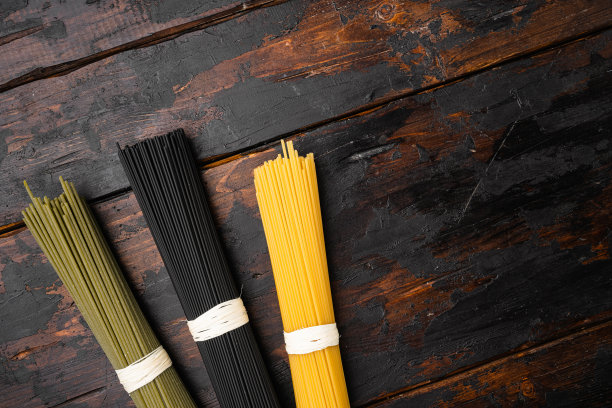 干彩色意大利面意大利面配料，在旧的深色木桌背景上，顶视图平放，与文本的复制空间图片下载