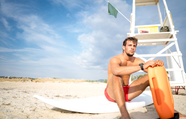 救生员坐在一个浮标旁边图片下载