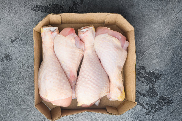 家庭装新鲜鸡腿，在纸包，在灰色的石头背景上，顶视图平lay图片下载