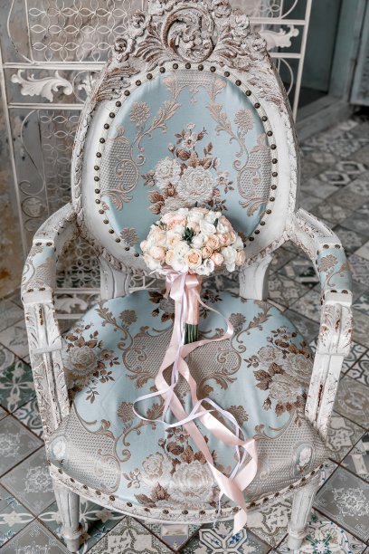 蓝色的椅子上放着白色和浅粉色的玫瑰图片下载