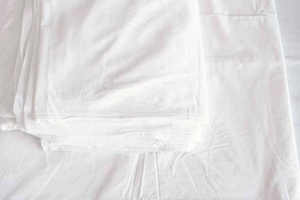 卧室里有白色舒适的床和柔软的枕头。旅馆卧室里的白色毯子。图片下载