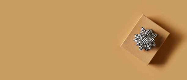 父亲节的概念与牛皮纸礼物和鞠躬在棕色的背景图片下载