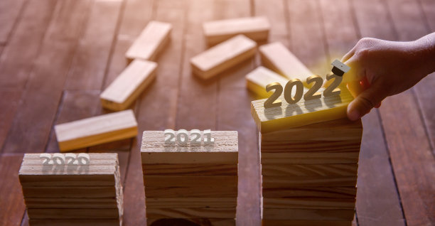 孩子的手放在一个木块上，上面写着2020-2022年的年数图片下载