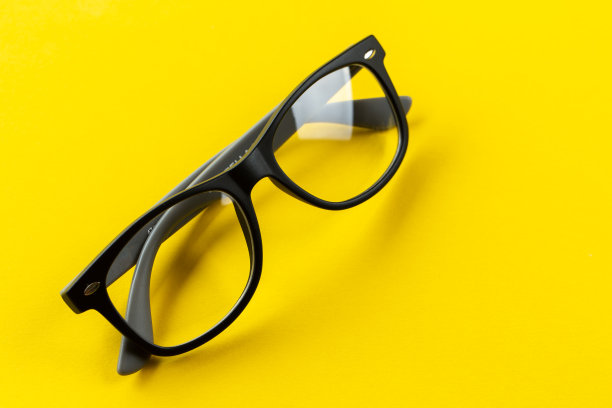 时尚的眼镜，黄色背景。眼镜挑选，验光，验光，时尚配饰概念。俯视图，平铺。图片下载