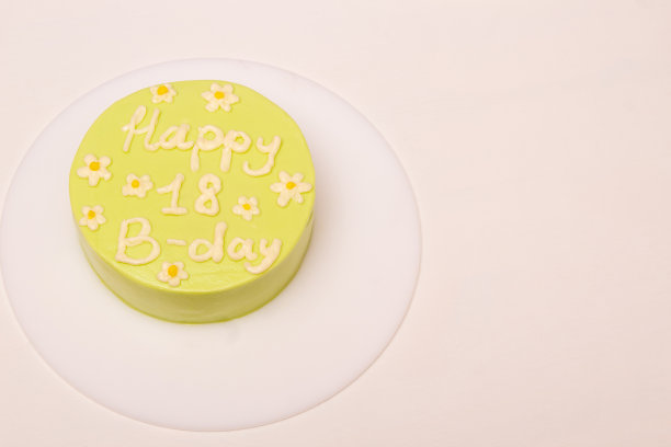 绿色便当蛋糕上写着18岁生日快乐。白色背景，放置文字。特写镜头。糖果产品广告。有选择性的重点。图片下载