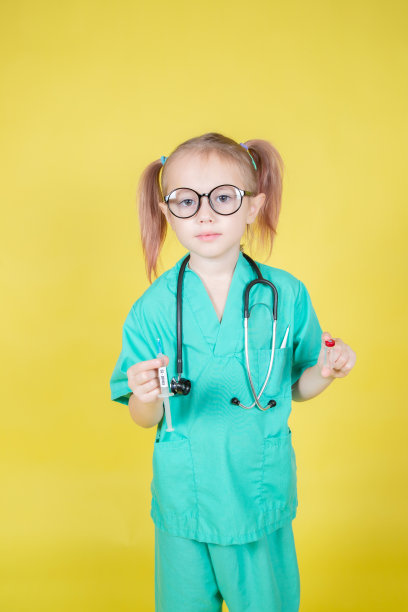 一个小女孩的肖像，穿着医生的外套，带着注射器和药瓶图片下载
