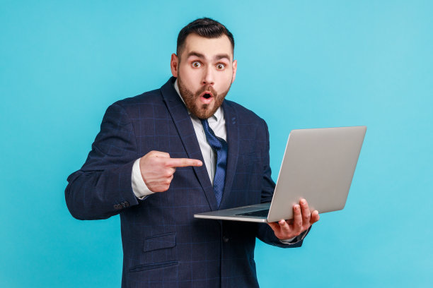 拿着笔记本电脑的震惊胡须男肖像图片下载