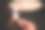 在一片漆黑中，一个女人的手拿着燃烧着的蜡烛，看着家里关掉的灯泡。图片下载