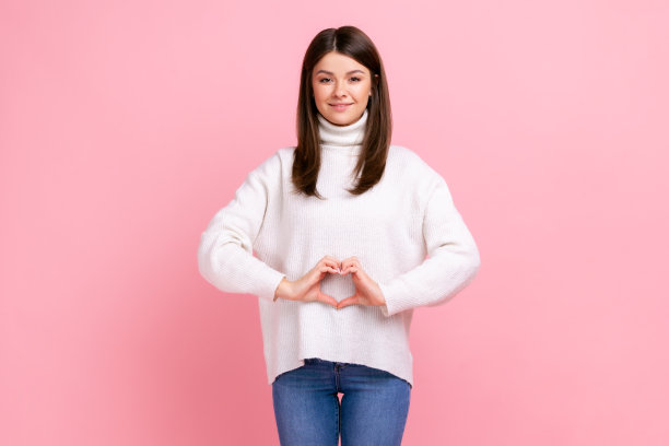 积极乐观的黑发女性，腹部前露心形，象征女性健康。图片下载