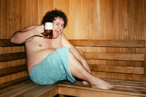 有趣的胖子正在桑拿浴中放松。图片下载