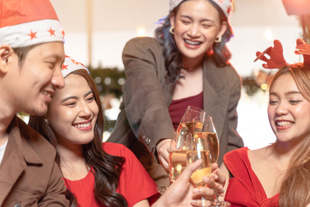 美丽的亚洲朋友男女聚会庆祝。幸福的朋友们，平安夜庆祝晚宴，有美食，有香槟。人们谈笑风生，欢声笑语。图片下载