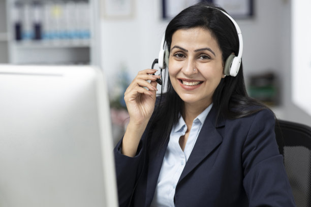 迷人的女商人坐在室内办公室的桌子上，工作。库存图片图片下载