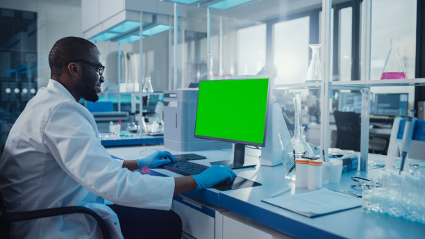 现代医学研究实验室:科学家在显示绿色色度键屏幕的计算机上工作。科学实验室，先进设备医学开发设施，生物技术。图片下载