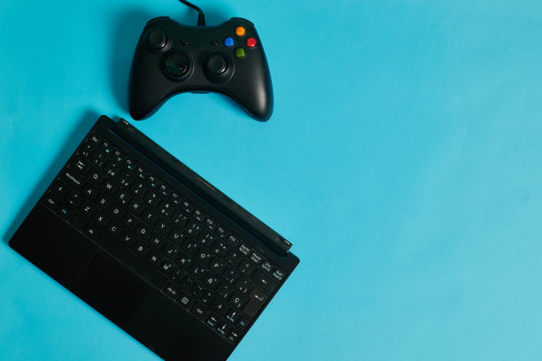 游戏控制台控制器和键盘上的蓝色背景图片下载