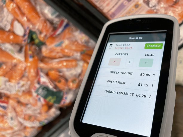 无法辨认的人拿着便携式价格扫描仪在超市购物的特写照片，Covid-19社交距离做法图片下载