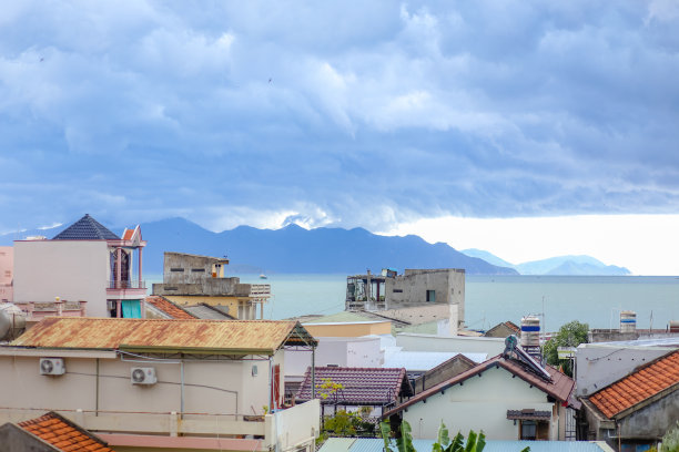 鸟瞰图，在庆和省芽庄湾，海岸附近的房屋以山脉为背景图片下载
