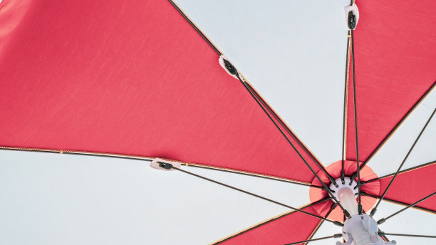 伞的海滩。红色夏日沙滩阳伞在蓝色的大海背景上。度假旅行用遮阳伞。户外休闲度假在海洋与复制空间。图片下载