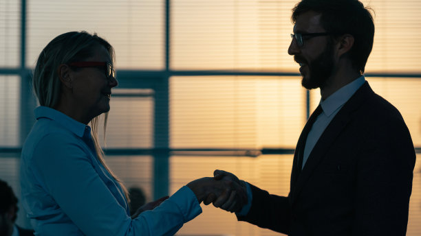 关闭了。一位女商人正在和一位年轻的雇员握手图片下载