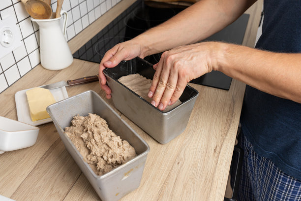 黑麦面包的制作过程黑麦面包上的生面团放在模子里。平滑工件的顶部。图片下载