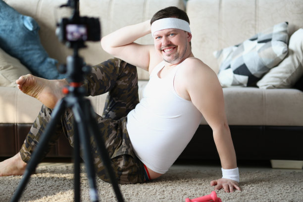 一名中年男子用摄像机录下体育课的视频图片下载