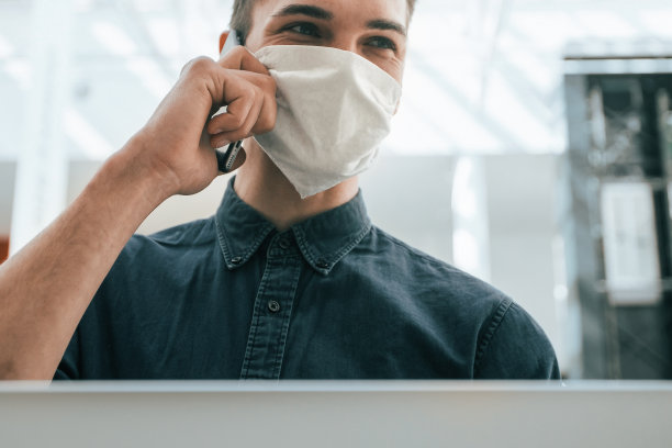 关闭了。一个戴着防护面具的年轻人在使用笔记本电脑图片下载