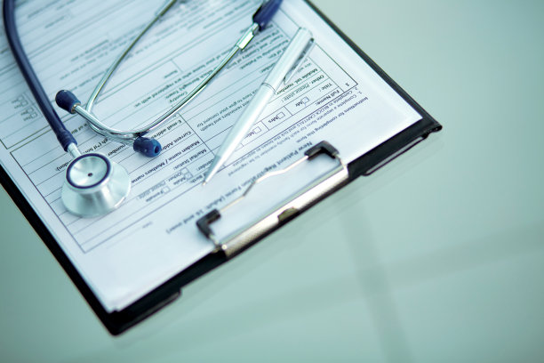 特写镜头。医生桌上的听诊器、钢笔和剪贴板图片下载