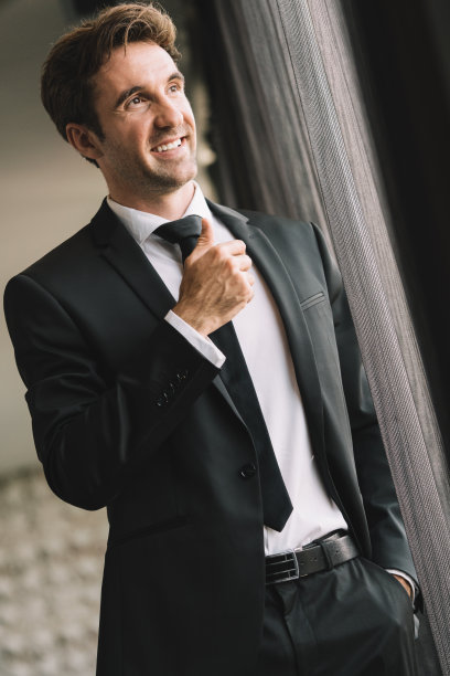 年轻英俊的男子放松在他的公寓在酒店商务会议后。图片下载