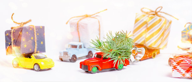 送货，圣诞，新年概念。复制空间，选择性聚焦。圣诞节庆祝概念。圣诞节即将来临。白色背景上有一棵圣诞树的红色复古小玩具车。图片下载