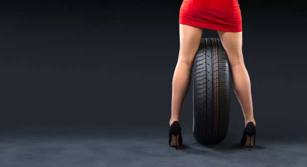 新的夏季轮胎和美丽的女性腿的女士穿着高跟鞋在黑暗的背景与复制空间。图片下载