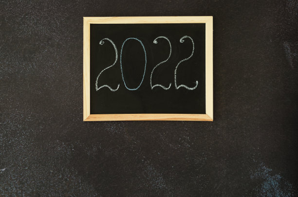 圣诞节，新年平躺在黑色的背景上。用一杯热咖啡来装饰圣诞节。书写板上的数字2022。仙人掌。前视图。副本的空间。模拟。图片下载