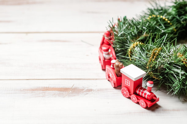 即将到来的新年，圣诞节的概念。新年的红色火车与绿色的树枝在白色的背景。图片下载