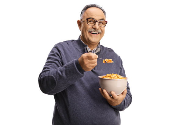 快乐的成熟男子吃一碗麦片粥图片下载