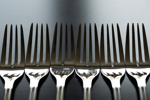 黑色背景上的餐具。叉子,勺子,小刀。图片下载