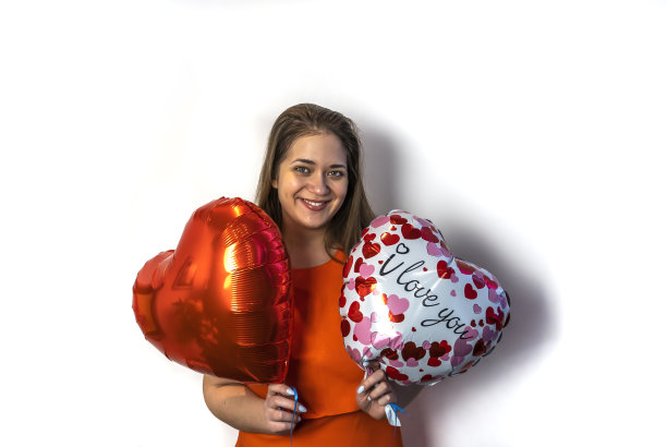 情人节快乐!一个拿着心形气球的年轻女人图片下载