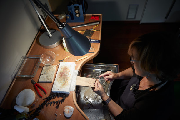 一位老妇人在她的车间里制作珠宝图片下载