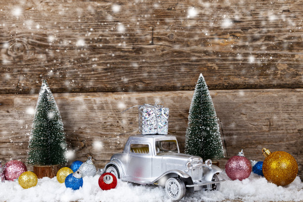 汽车上载着圣诞礼物。圣诞背景有雪花，图片下载