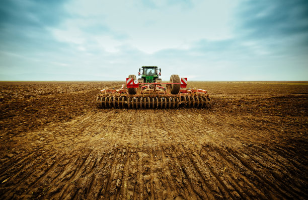 农民在拖拉机上用苗床耕耘机准备土地图片下载