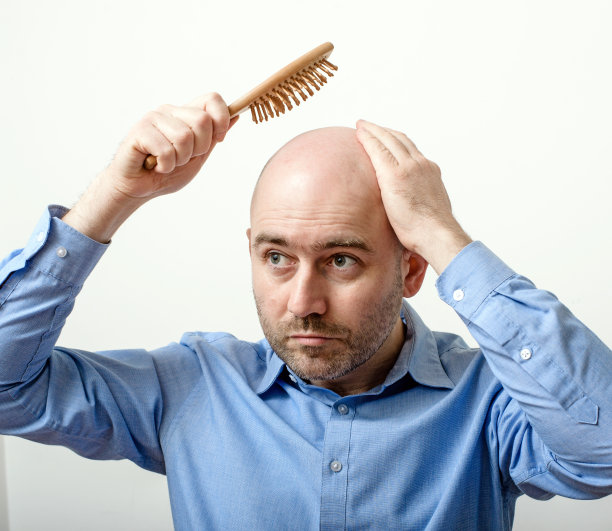 困惑的秃头男子与梳子图片下载