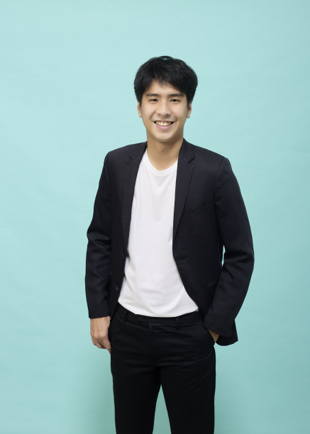 英俊的亚洲人在浅蓝色工作室背景黑色西装图片下载